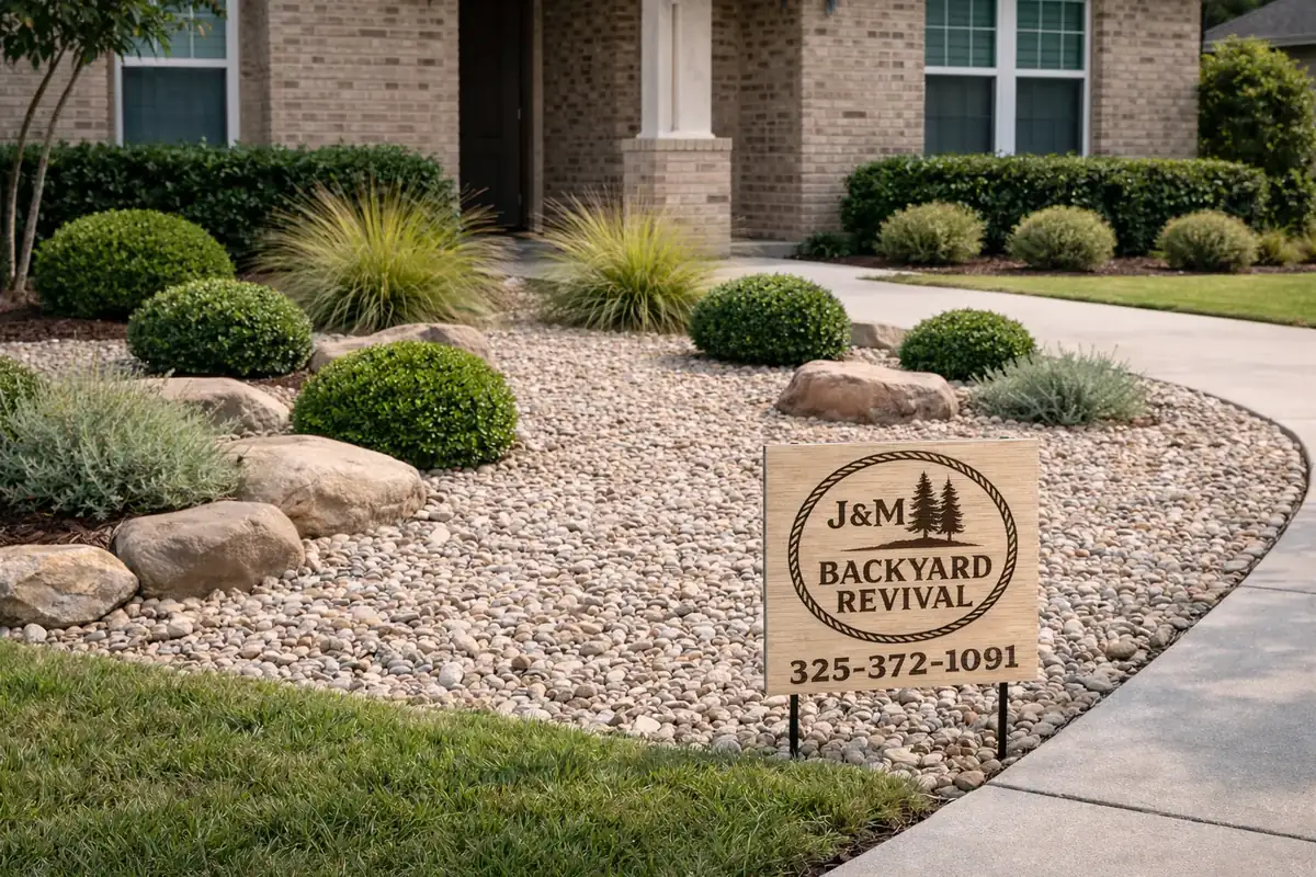 Rock bed landscaping with J&M Backyard Revival sign in San Saba, TX